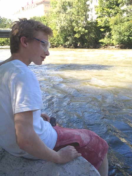 Paul Lässer sitzt auf dem geschliffenen Steinbrocken an der Mur. Er ist staubig vom Arbeiten, doch schaut zufrieden auf den Fluss.